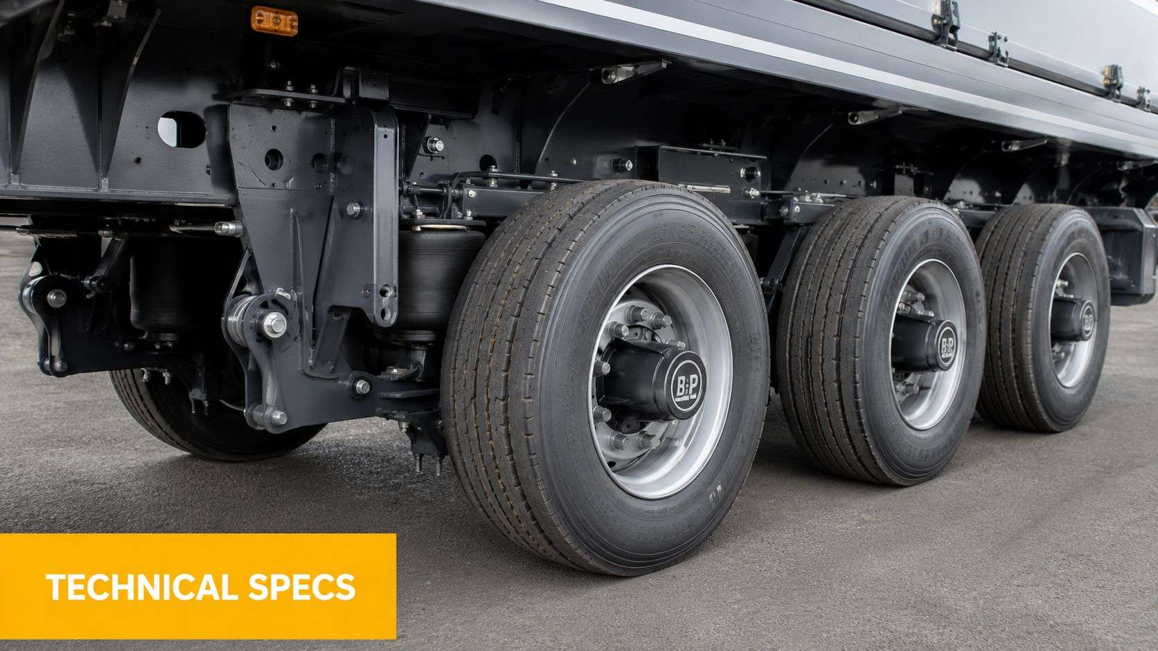 Close-up of the heavy-duty suspension and multiple wheels of a modern commercial single drop trailer.